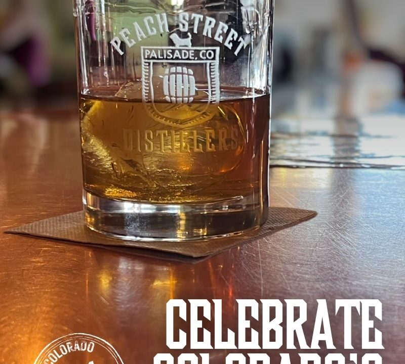 A glass of whiskey on a bar with Peach Street Distillers Palisade, CO etched on it. Text reads: Celebrate Colorado Craft Spirits with a round Colorado Distiller 001 stamp.