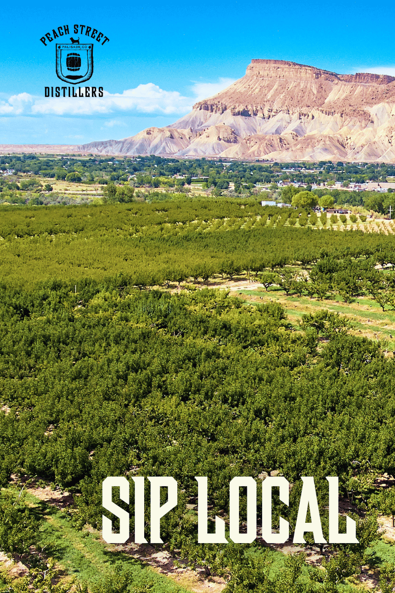 A panoramic view of a lush green orchard in Palisade, Colorado, with a mesa in the background under a blue sky. Text reads PEACH STREET DISTILLERS at the top and SIP LOCAL at the bottom—perfect for celebrating Earth Month.